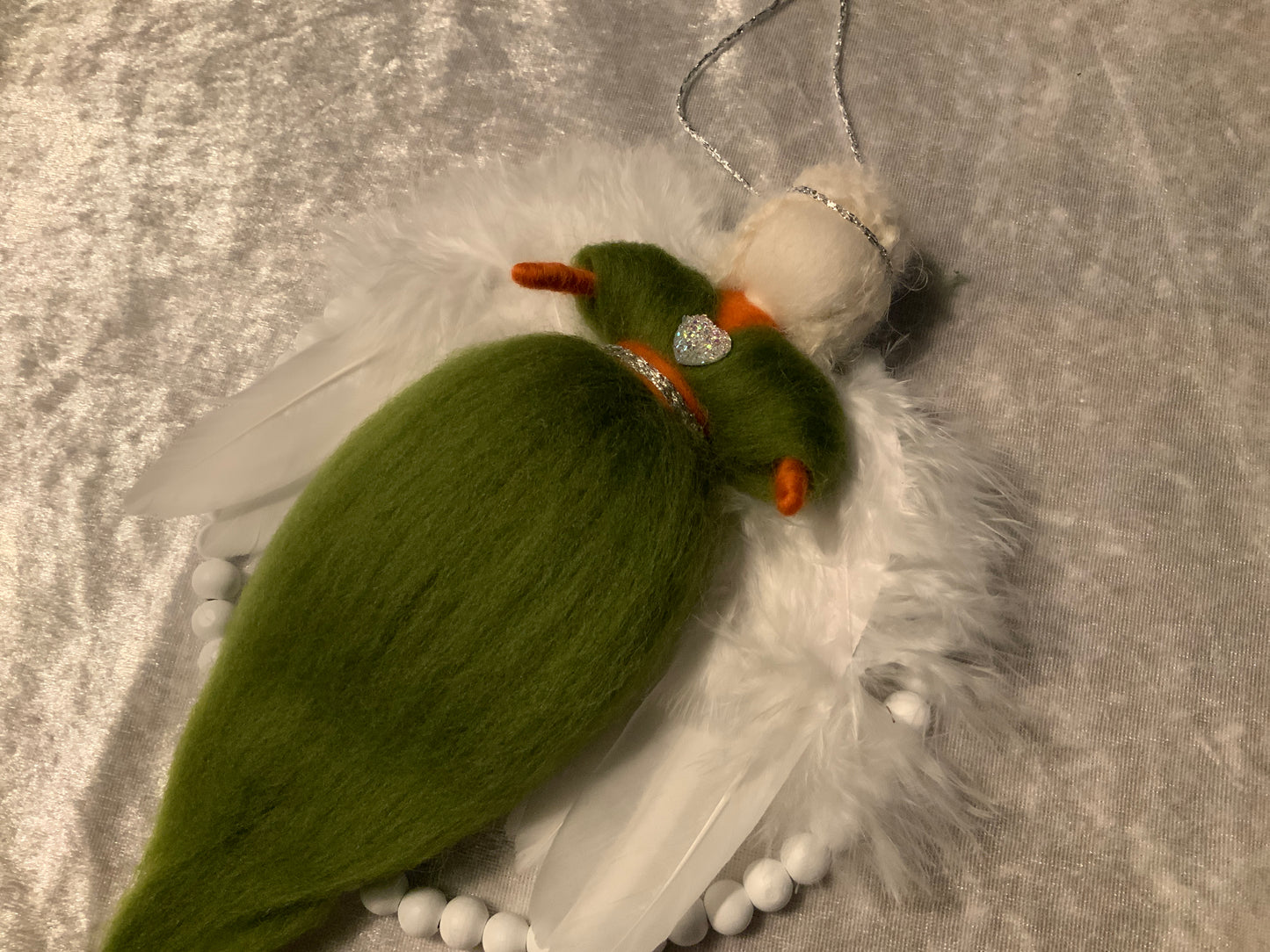 Handgefertigter Engel in einem Holzperlenkreis